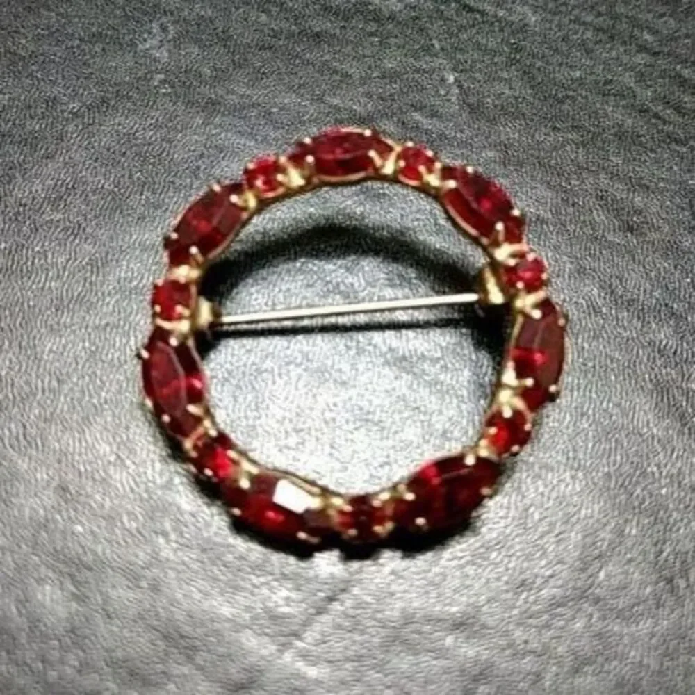 Vintage gold tone round pin w red rhinestones